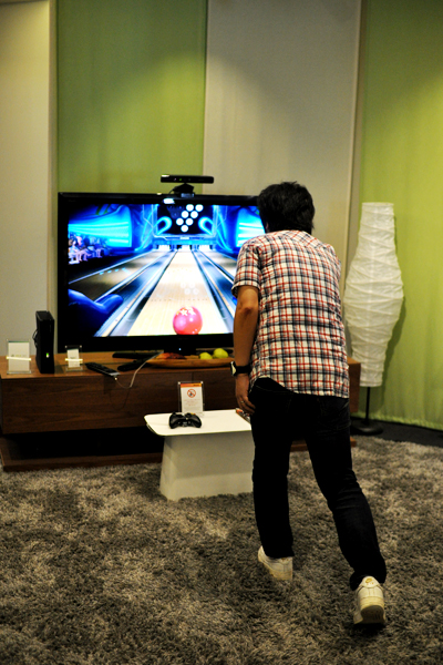 Xbox 360でボウリング中。コントローラを用いずジェスチャーや音声認識によって操作できる体感型のゲームシステム、Kinectを使用