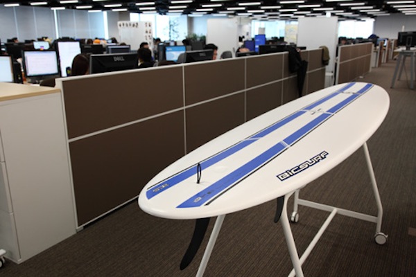 執務室にサーフボード? これはスタンディングのミーティングスペース。さながら宿り木。社内にはスタッフ同士が気軽にコミュニケーションをとれる場がたくさんある。同じく、いたるところに白壁と見せかけてホワイトボードを用意。新しいアイデアは豊富なコミュニケーションから生まれる