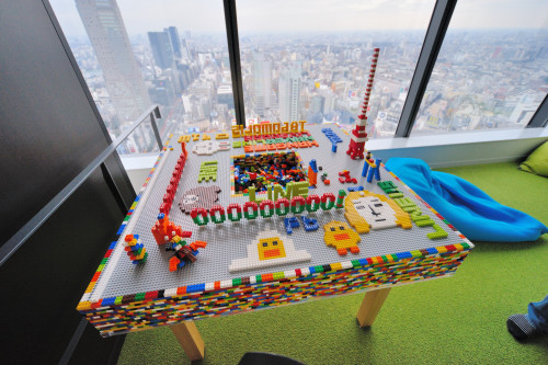 社内カフェを奥へと進むと、グリーンがまぶしいリラックススペース。カラフルなクッションに横たわりながら、おつかれ気味の人たちが休憩中