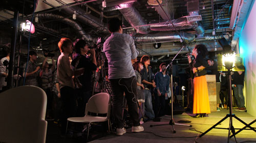 音楽・映像・デザインなどを融合した最新鋭の作品を生み出す総合クリエイティブ集団「GROUNDRIDDIM」全面協力のもと、ミュージシャンのchan-mikaとDJ UPPERCUTを招いて行われたミュージックビデオの撮影実習。駿河台ホールを利用した、実践に即した授業の一コマだ