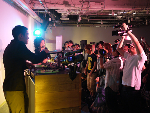 音楽・映像・デザインなどを融合した最新鋭の作品を生み出す総合クリエイティブ集団「GROUNDRIDDIM」全面協力のもと、ミュージシャンのchan-mikaとDJ UPPERCUTを招いて行われたミュージックビデオの撮影実習。駿河台ホールを利用した、実践に即した授業の一コマだ