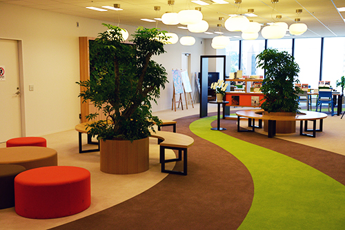 デジタルハリウッド株式会社のエントランスに設けられたウェイティングルーム。壁面緑化やセンスのいい本がディスプレイされた居心地のいい空間だ