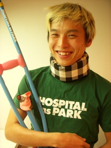 試作品を全部身につけてみました。チェックのギブス、牛の松葉づえ、そして「HOSPITAL AS PARK」のロゴTシャツ