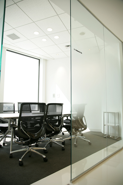 ミーティングルーム内。据え付けられたのはホワイトボードならぬシルバーボード？　いやよく見ると透明ボード？