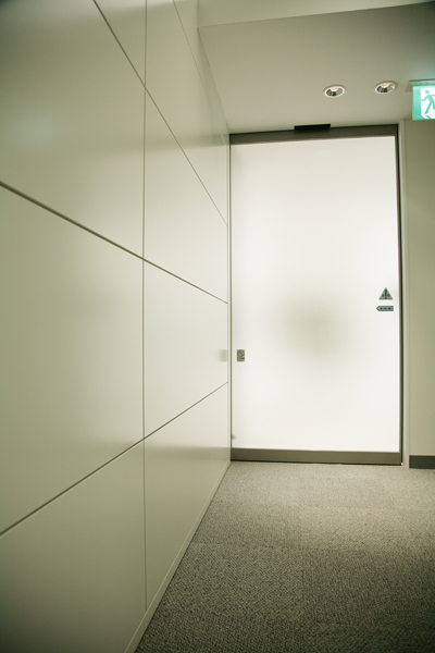 ゲスト待合スペースと執務室とをつなぐ出入口。すりガラスの自動ドアがちょっぴり近未来的