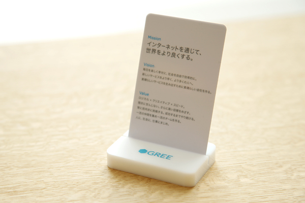 写真上から、グリーの使命がつづられたミッションステートメントカード、今年1月に開かれた納会の記念写真、会社ロゴの入ったマグカップ。これらは会社から社員に送られたノベルティ