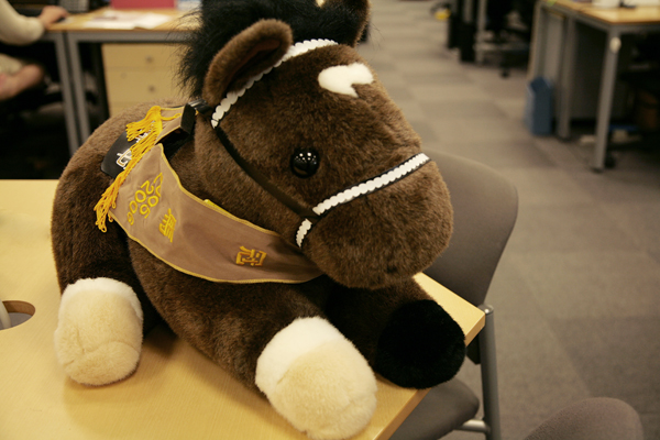 写真上は、上場を記念して取引先からプレゼントされた造花。下も同じく上場記念にいただいたディープインパクトのぬいぐるみ