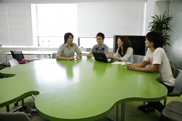 Ameba状の特大変型テーブルでミーティング。ミーティングルームを抑えるまでもなく、サッと集まるのにぴったりな場所