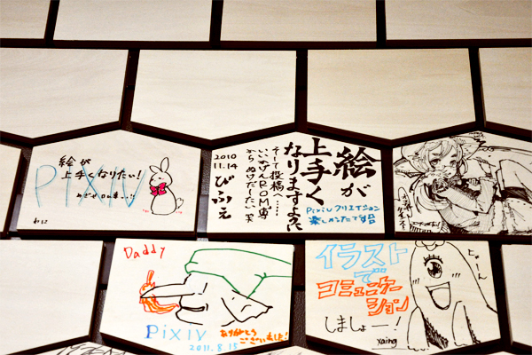 イラストが描かれた、たくさんの絵馬がディスプレイされたエントランス。オフィスを移転した2010年9月の段階での絵馬は何も描かれていなかったが、現在では約300点にアートワークがある。オフィスに立ち寄った作家さんたちが、色紙代わりに作品を残していく