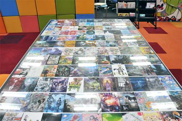 pixivフェスタに展示された作品のポストカードがズラリとはさまれたミーティング用のデスク