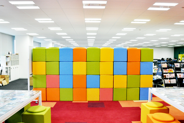 打合せスペースのサイドにうず高く積まれたカラフルなイス「キューブ」。打合せ用のイスにもなるが、写真のようにスタッキングしておけばパーティションにもなる便利グッズ。形もかわいい