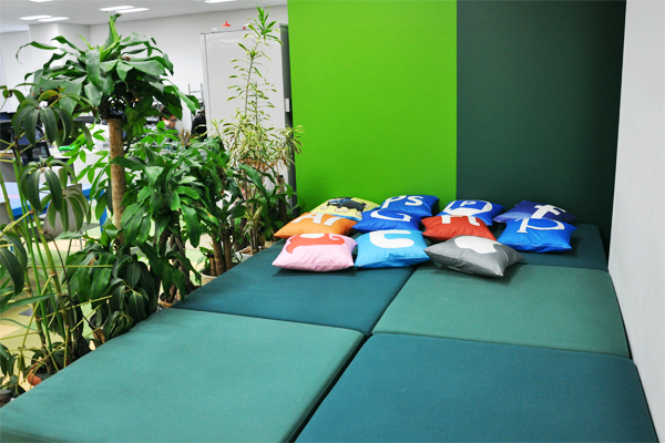ハードワーカーの味方、休憩スペース。というかベッド？　ここで熟睡してしまう社員も少なからずいるとか。添えられたクッションには、IT関係の人にはおなじみのロゴが