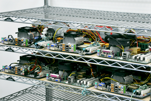 オープンラックにパーツむき出しのままズラリ並べられた自作のサーバー。これらは開発段階でテストに使用するもの。写真下のものは現在も稼働中