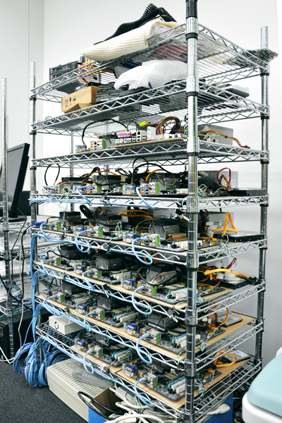 オープンラックにパーツむき出しのままズラリ並べられた自作のサーバー。これらは開発段階でテストに使用するもの。写真下のものは現在も稼働中