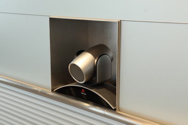 海外の人との打合せに使用するミーティングルーム。ホワイトボードを兼ねたスクリーンに相手の様子が映し出される。部屋の壁に設置されたマジックミラー越しには、通訳ブースも併設。主にエグゼクティブが使用するスペースであるせいか、インテリアはどことなくラグジュアリー