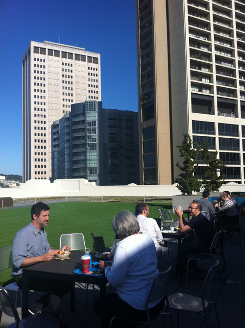 出社後、カフェで好きなものを手にして、そのまま外のテーブルに向かうスタッフたち