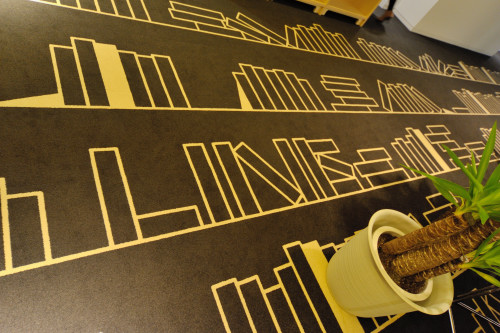 現在急ピッチで準備が進められている社内ライブラリー。床を彩る白いラインは本。と見せかけて、よく見ると「NHN」「LINE」の文字!?