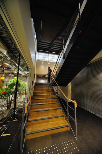 ビルの27階と28階をつなぐ階段。工事中のフェンスを模したインテリアがユニーク