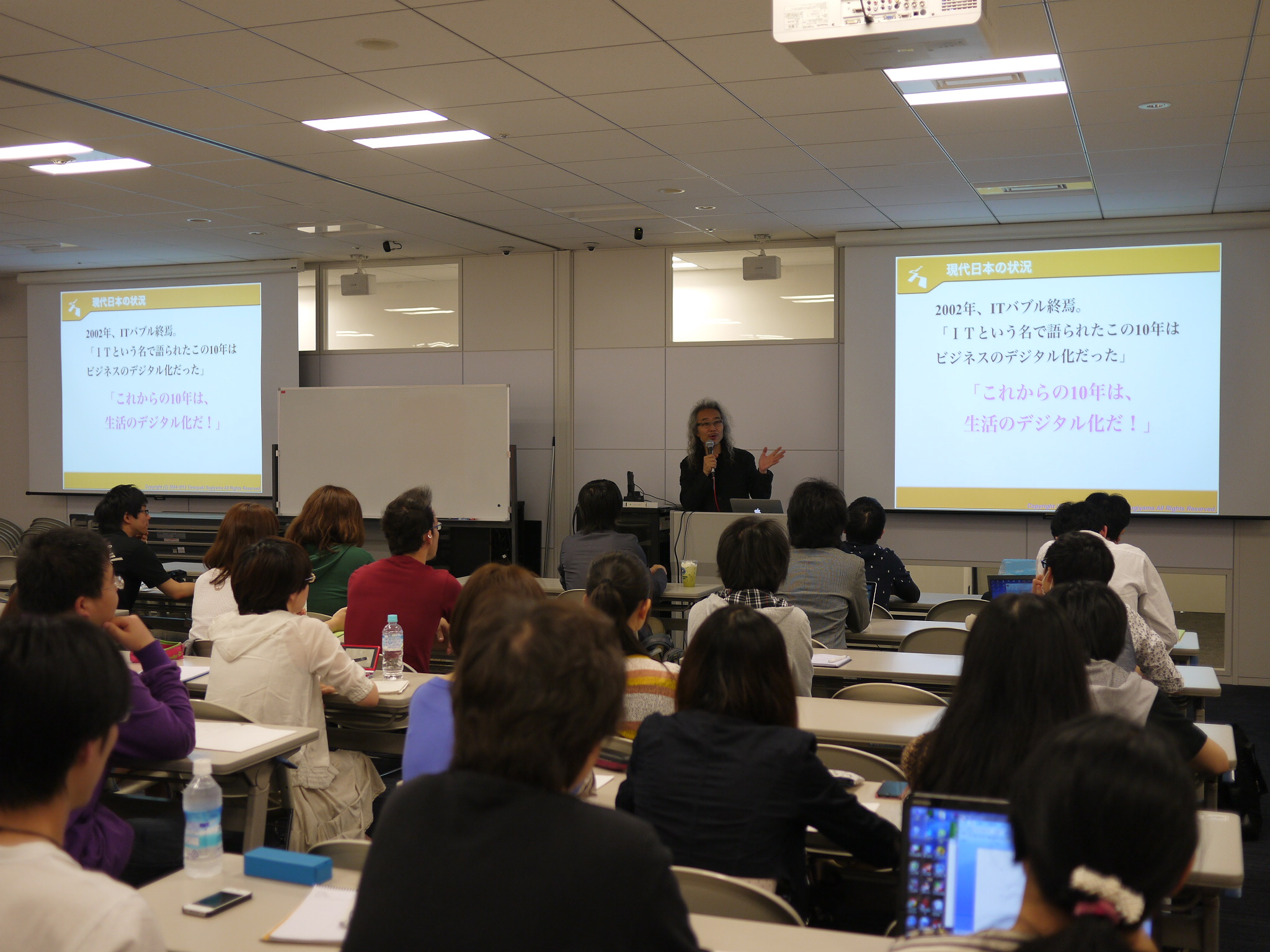 大学院の授業、杉山学長による「デジタルコミュニケーション原論」。大阪のサテライトキャンパス在籍の院生のために、リアルタイムでの動画配信を行っている。東京側には、大阪キャンパスの院生たちの様子も映し出される