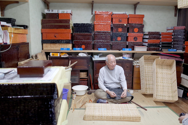 店内に併設された作業場で、6代目の岩井良一さんがつづらを作っている。よい香りの正体は、これからつづらになる竹の籠