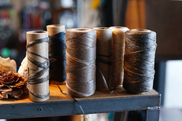 <span style="color: #666699;">手縫いで使用している蝋引きの糸。必要に応じて割いたり、捩じりを加えて強度を高めて使っている</span>