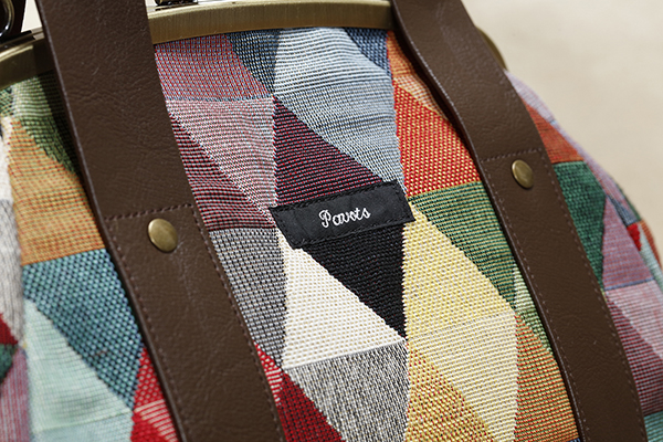 ゴブラン織りの表面は素朴な印象。落ち着いた色でまとめられているので、どんなファッションと合わせてもお洒落に決まる