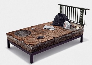 ホームレスが寝る路上を再現した「世界で最も寝心地の悪いベッド」、サミットで展示