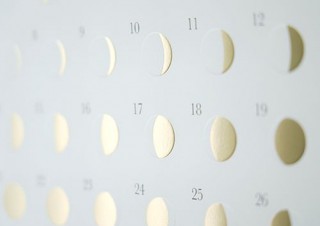 白紙にエンボス加工と金の箔押しで月の満ち欠けを表現した壁掛けカレンダー「ミチル kira」