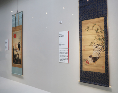 左： 伊藤若冲《旭日雄鶏図（きょくじつゆうけいず）》 　109.4×48.8cm 米国・エツコ＆ジョー・プライスコレクション／通期展示 右： 伊藤若冲《梔子雄鶏図（くちなしゆうけいず）》 　85.8×43.1cm 個人蔵／通期展示